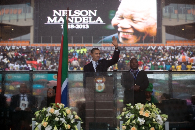 United States President Barack Obama speaks at the memorial service for Nelson Mandela in Soccer Stadium, Soweto, South Africa on 10 December 2013. Thamsanqa Jantjie stands to the right.